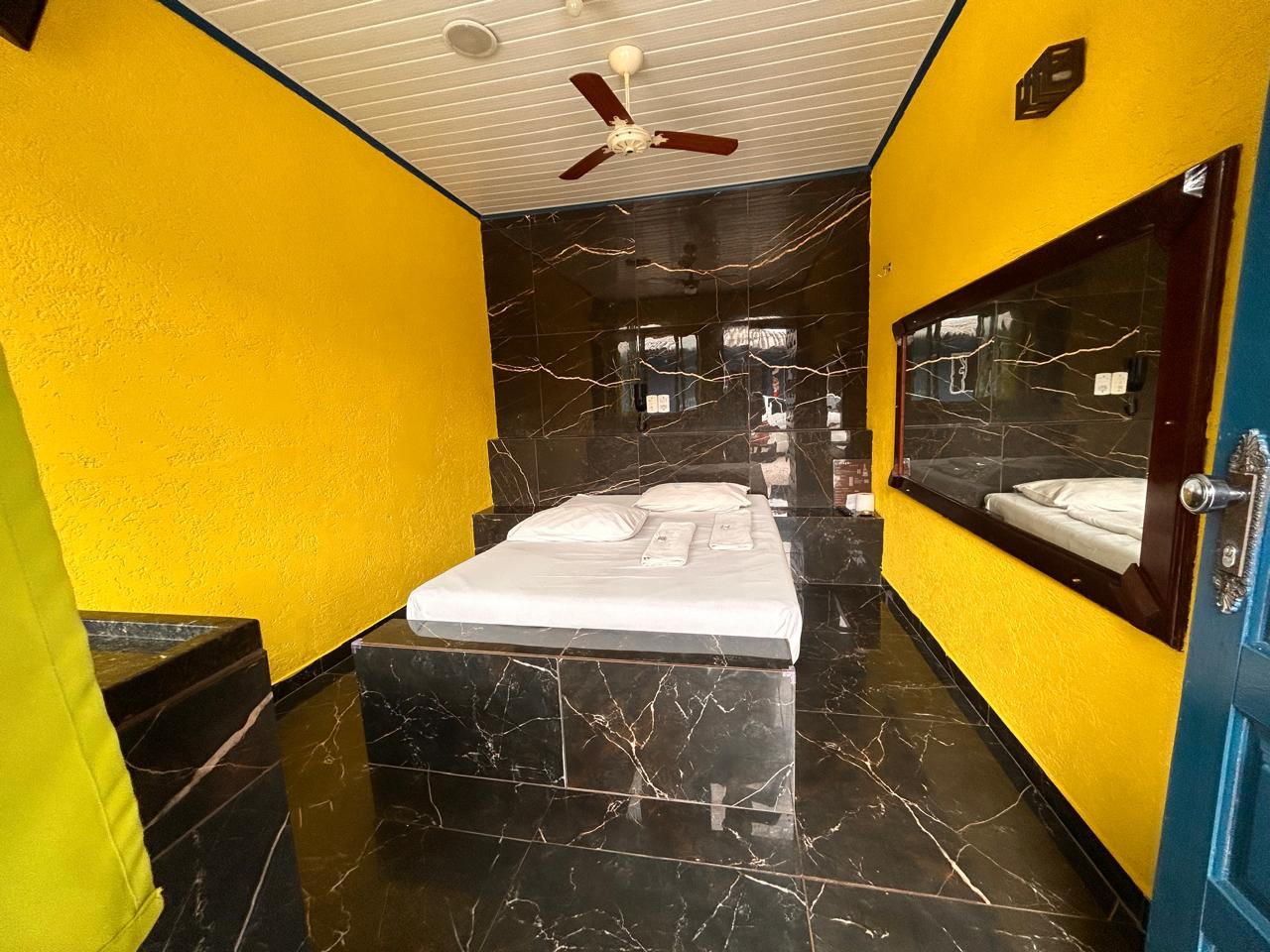 Suíte com paredes amarelas e piso em mármore preto