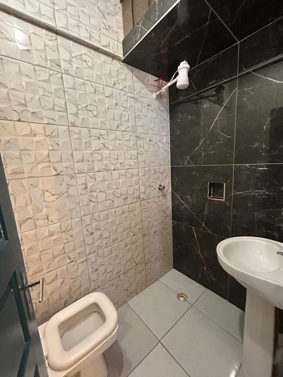 Banheiro privativo com acabamento em mármore preto e branco