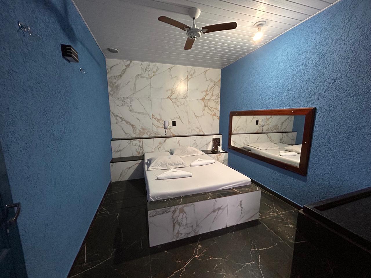Suíte com paredes azuis e detalhes em mármore